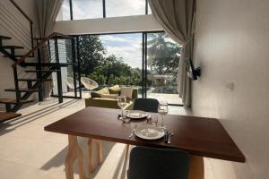 een eetkamer met een houten tafel met wijnglazen bij Sumba Luxury Cottages Pool & Jacuzzi in Ko Pha Ngan