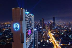 a building with a sign on the side of it at night at Banyan Tree Bangkok in Bangkok