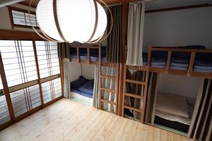 a room with three bunk beds and a window at yol Guesthouse ヨルゲストハウス in Takeo