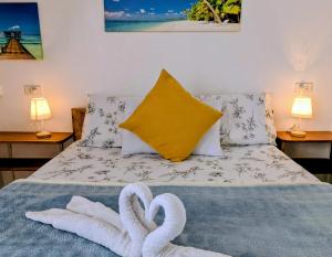 two towels on a bed with two swans on it at Astillo's Guest Houses in Moalboal