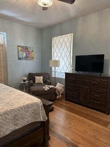 a bedroom with a bed and a flat screen tv at BellaDonna By The Bay in Bridgetown