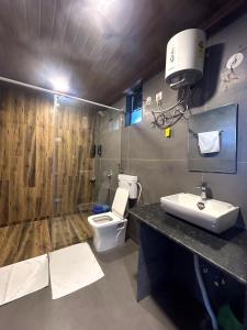 a bathroom with a toilet and a sink and a shower at Vandhaara Luxury Stays in Pune