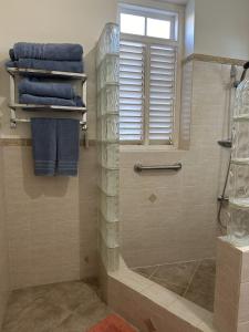 a bathroom with a shower with blue towels at BellaDonna By The Bay in Bridgetown +18 photos