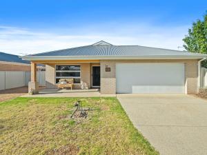 een huis met een garage en een hond in de tuin bij Tenang Escape Yarrawonga in Yarrawonga