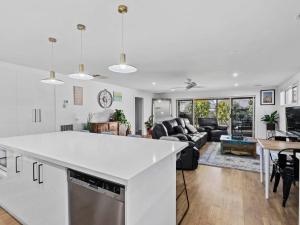 een keuken en een woonkamer met een wit aanrecht bij Tenang Escape Yarrawonga in Yarrawonga
