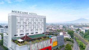 a hotel with a sign on top of a building at Mercure Solo in Solo