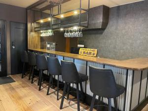 a bar with a row of black bar stools at Restmance Pension Woody Hill in Iiyama