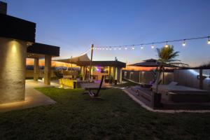 Een achtertuin van een huis met terrasmeubilair en verlichting. bij House California 