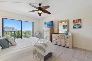 een slaapkamer met een bed, een ladekast en een raam bij Windrush 509 in Cocoa Beach