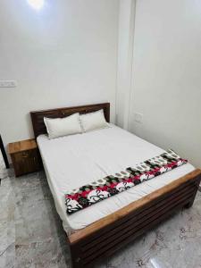 een slaapkamer met een bed met witte lakens en bloemen bij Dubai Inn in Kanjirapalli