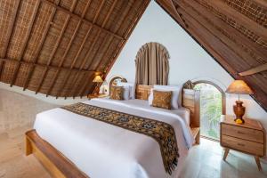 een slaapkamer met een wit bed en een raam bij Govala Usada Ubud Villa in Ubud +36 foto's