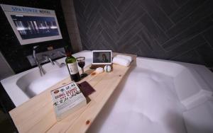 eine Badewanne mit einer Flasche Wein und einem Schild darauf in der Unterkunft Spa Tower Motel in Daejeon + 14 Fotos