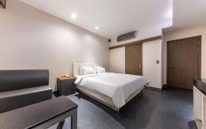 a bedroom with a bed and a couch in it at Spa Tower Motel in Daejeon