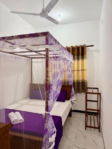 a bedroom with a bed with a canopy at Midigama Lucky Villa in Midigama East