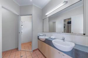 een badkamer met twee wastafels en een spiegel bij Spa Haven 18A in Airlie Beach