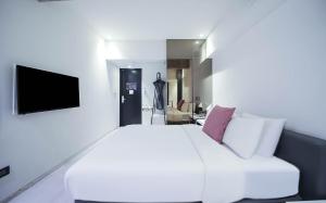 a bedroom with a white bed and a tv at BROWN DOT Hotel Dadaepo Beach in Busan