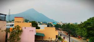 a view of a city with a mountain in the background at Guru Rooms in Tiruvannāmalai
