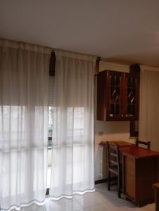 a kitchen with white curtains and a table at Carinissimo vicino a Venezia in Jesolo +6 photos