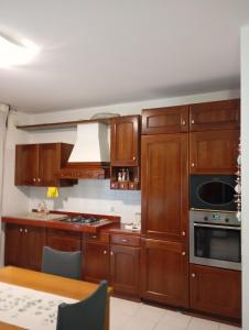 a kitchen with wooden cabinets and a stove top oven at Carinissimo vicino a Venezia in Jesolo