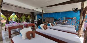 una camera con tre letti e una parete con un murale di Morning Walsh Resort El Nido a El Nido