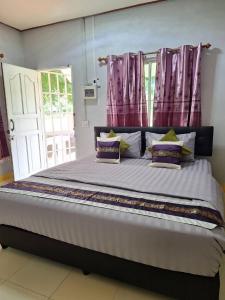 ein Schlafzimmer mit einem großen Bett mit lila Vorhängen in der Unterkunft Baan Suan Thada Thai บ้านสวนธาดา ไทย in Wang Nam Yen + 27 Fotos