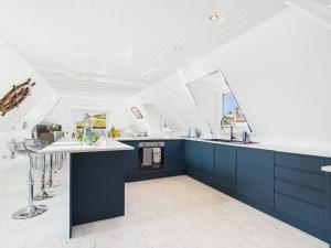 een keuken met blauwe kasten en een wit plafond bij The Boathouse in Torquay