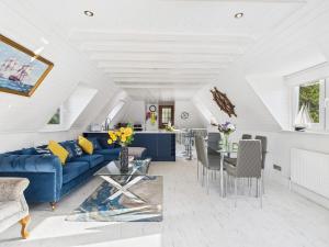 een woonkamer met een blauwe bank en een tafel bij The Boathouse in Torquay +15 foto's