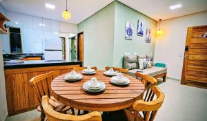 une cuisine et une salle à manger avec une table et des chaises en bois dans l'établissement Casas Costa Dos Corais, à Japaratinga 32 autres photos