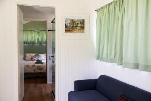 a living room with a blue couch and a bedroom at The Glan Devon Tiny Retreat in Glan Devon