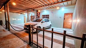 une voiture blanche est garée dans un garage dans l'établissement Casas Costa Dos Corais, à Japaratinga