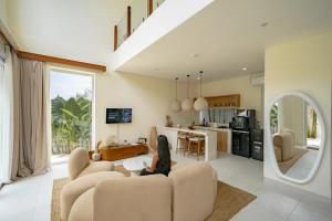 a woman sitting on a couch in a living room at Lyma Loft Pererenan in Canggu