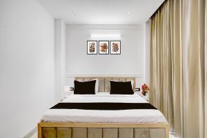 a bedroom with a large bed with black and white sheets at Townhouse Sector 49 Gurugram Formerly Hotel P66 in Gurgaon