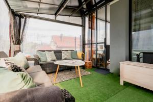 un soggiorno con un divano e un tavolo di Matisse Apartment a Białystok