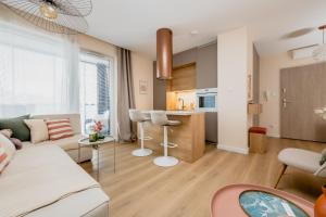 un soggiorno con divano e cucina di Matisse Apartment a Białystok