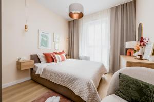 una piccola camera da letto con un letto e una sedia di Matisse Apartment a Białystok Altre 13 foto