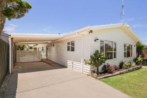 a white house with a driveway at Barramundi Beach House in Smiths Beach