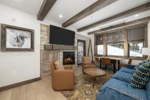 a living room with a blue couch and a fireplace at Select Unit 2509 - Zephyr Mountain Lodge condo in Winter Park