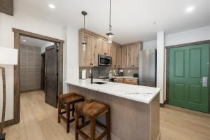 a kitchen with wooden cabinets and a green door at Select Unit 2509 - Zephyr Mountain Lodge condo in Winter Park
