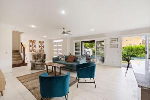 een woonkamer met een bank, een tafel en stoelen bij Caba Coast Retreat in Cabarita Beach