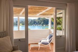 a room with a balcony with a view of the water at Boatsheds on the Bay, Waiheke Island in Ostend