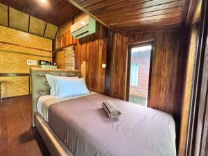 丽贝岛湾景山度假村的一间带床的卧室，位于一间带木墙的房间里