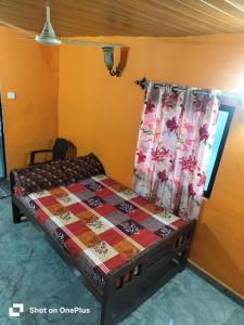 ein Schlafzimmer mit einem Bett mit einer Steppdecke darauf in der Unterkunft Swastik Guest House in Arambol