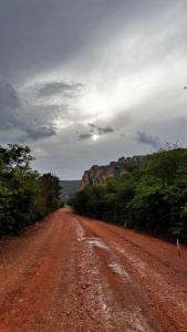 eine unbefestigte Straße mit einem Berg in der Ferne in der Unterkunft Pousada na serra da capivara in Coronel José Diaz