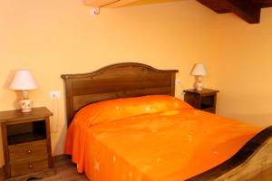 a bedroom with an orange bed with two night stands at Nonno Domenico in Sassano