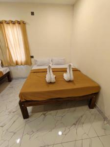 a bedroom with a bed with towels on it at VISAI Retreat in Tiruvannāmalai +43 photos