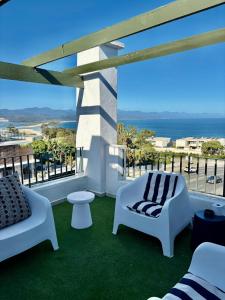 a balcony with two chairs and a view of the ocean at Kana Vista in Plettenberg Bay