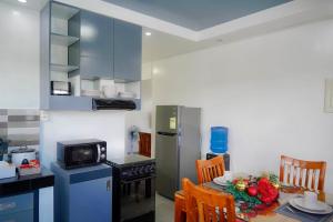 a small kitchen with a table and a refrigerator at Max n Fe in Iriga City