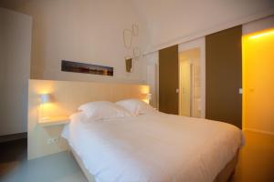 a bedroom with a large white bed with two lamps at Antwerp For Two B&B in Antwerp