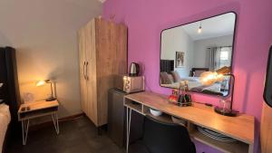 een kamer met een bureau en een bed met een spiegel bij The Chameleon Stay @107 in Centurion