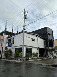 a white building on the side of a street at rõõm collective in Odiongan